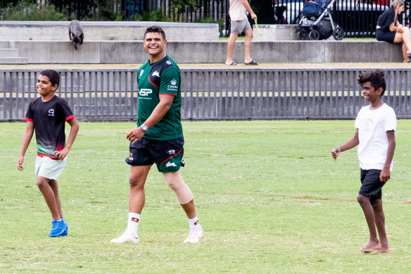 Rabbitohs star Latrell Mitchell is back at training on Monday, sharing a laugh with two visiting children.