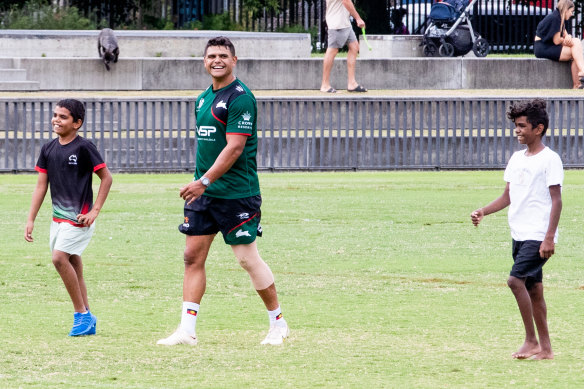 Rabbitohs star Latrell Mitchell back at training on Monday, sharing a laugh with two visiting children.