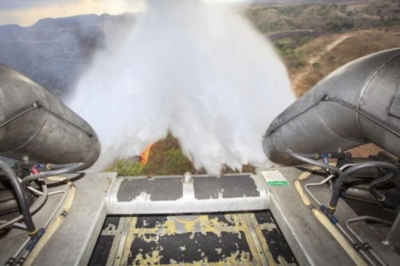 In this photo released by Brazil's Ministry of Defence, a C-130 Hercules aircraft dumps water to fight fires raging in the Amazon.