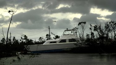 A US Coast Guard helicopter flies over the areas affected by Hurricane Dorian as a catamaran lays stranded.