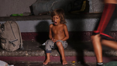 A child yawns after he is woken from his sleep by Mexican immigration authorities who arrived to push out camping migrant families from a park in Tapachula, Mexico, on Wednesday.