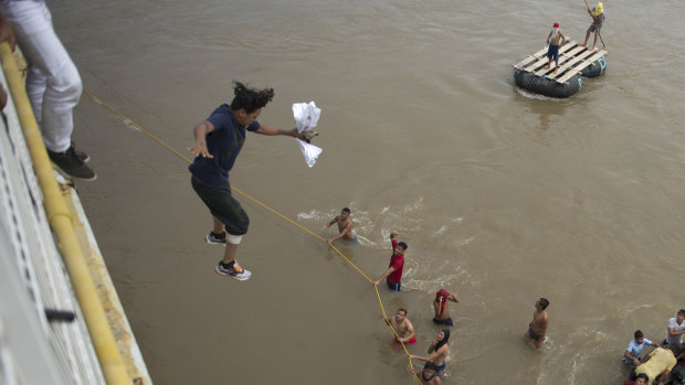 Migrants tired of waiting to cross into Mexico, jumped from a border bridge into the Suchiate River, in Tecun Uman, Guatemala, on Friday.