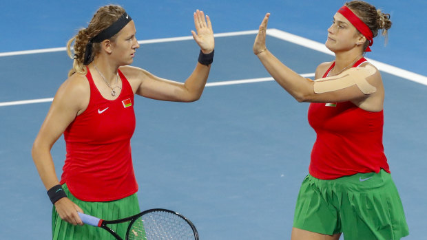 Aryna Sabalenka (right) and Victoria Azarenka (left) of Belarus celebrate winning the second set in the decisive fifth rubber.
