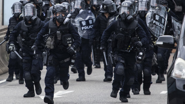 Riot police charge towards protesters on Lung Wo Road during a protest against a proposed extradition law in Hong Kong.