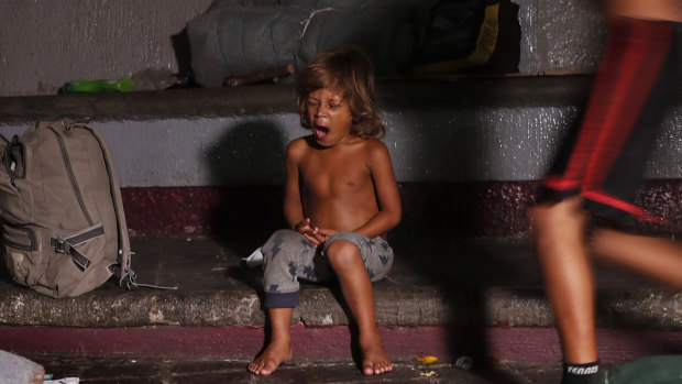 A child yawns after he is woken from his sleep by Mexican immigration authorities who arrived to push out camping migrant families from a park in Tapachula, Mexico, on Wednesday.