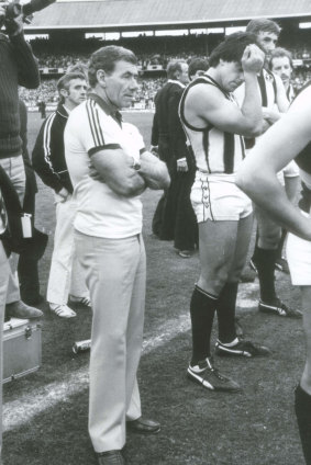Collingwood coach Tom Hafey stands with his players after their loss.