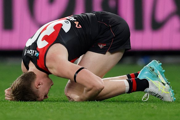 Essendon’s Angus Clarke reels after getting a knock.