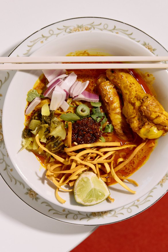 Khao soi egg noodle soup topped with braised chicken.
