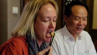 Fairfax China Correspondent Kirsty Needham tasting a fried American cockroach at a local restaurant.