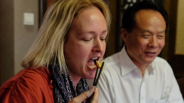 Fairfax China Correspondent Kirsty Needham tasting a fried American cockroach at a local restaurant.