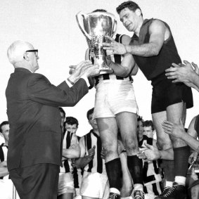 Melbourne's Ron Barassi receives the 1964 premiership cup.