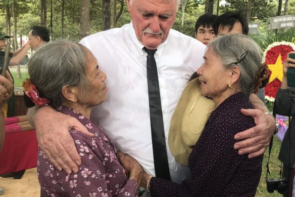 John Bryant embraces the sisters of North Vietnamese soldier Nguyen Van Ha, who Bryant believes he may have killed in 1968.