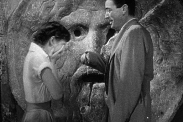 A scene from Roman Holiday starring Gregory Peck, Audrey Hepburn and the Mouth of Truth.