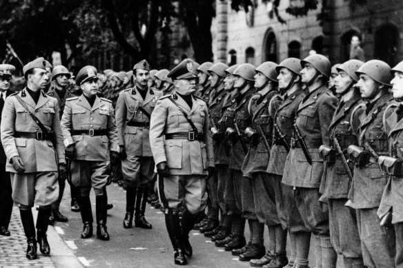 Italian Premier Benito Mussolini, right, and members of his staff review troops of the newly formed Fascist battalions on the outskirts of Rome, Italy on October 19, 1941.