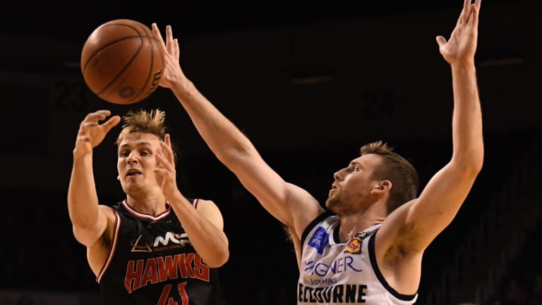 Emmett Naar of the Hawks shoots past Mitch McCarron of United.