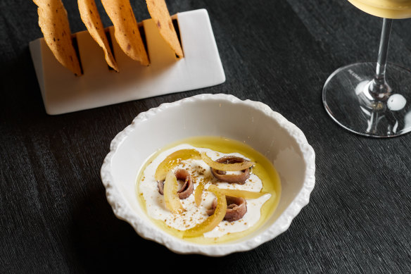 Rosemary carasau with smoked stracciatella, anchovies and pickled tomatoes.