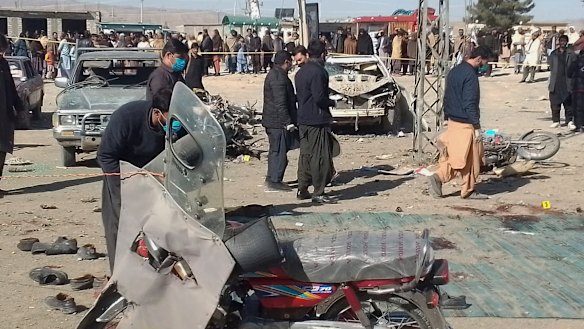 Security officials examine the scene of a bomb blast in Pakistan one day before elections are held.