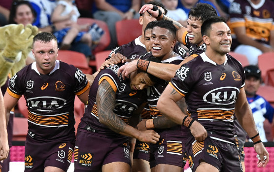 The Broncos mob try-scorer Jamayne Isaako during their win over the Bulldogs.