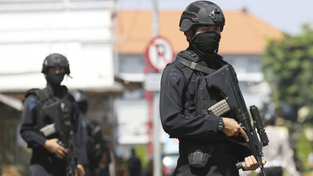 Officers stand guard outside the local police headquarters following an attack in Surabaya, East Java, Indonesia, on Monday.