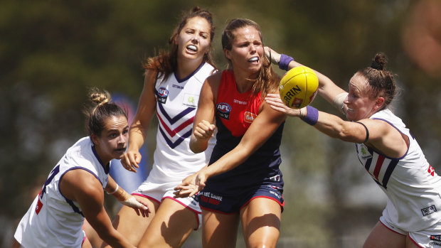 In the thick of it: Kate Hore handpasses out under pressure during the Demons' round one match against Fremantle.