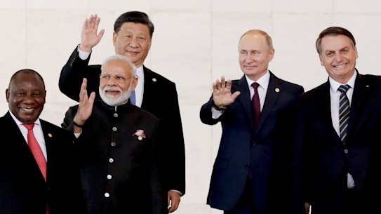 From left to right, South Africa's President Cyril Ramaphosa, India's Prime Minister Narendra Modi, China's President Xi Jinping, Russia's President Vladimir Putin and Brazil's President Jair Bolsonaro wave to photographers during the BRICS Summit in Brasilia.