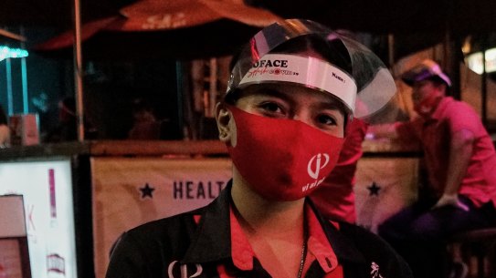 Sri Ekayani, a waitress at Vi Ai Pi, a famous hang out on Legian street in Bali, showing off the establishment's specials.