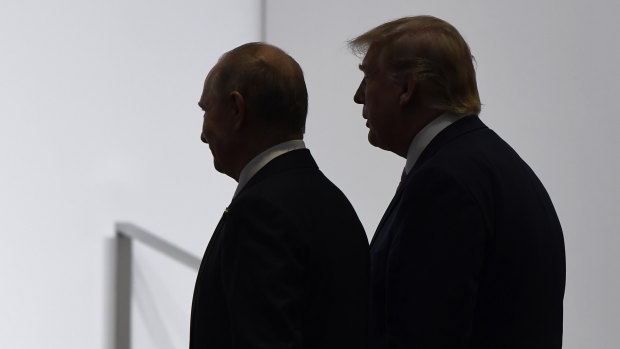 President Donald Trump and Russian President Vladimir Putin walk to participate in a group photo at the G20 summit in Osaka, Japan in 2019.