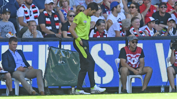 Turf war: The emergency umpire fixes the playing surface at Marvel Stadium during the round one match between St Kilda and Gold Coast.