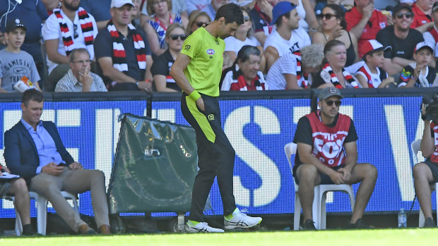 Turf war: The emergency umpire fixes the playing surface at Marvel Stadium during the round one match between St Kilda and Gold Coast.