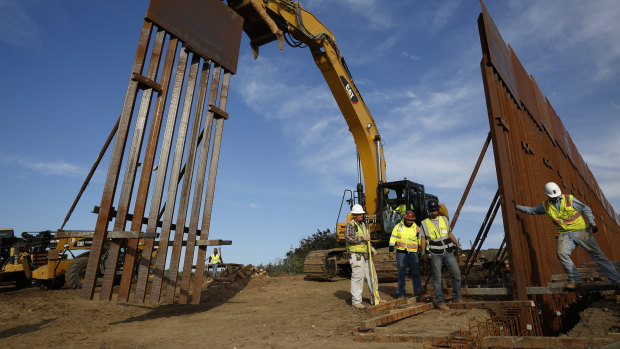 Construction workers install new border wall sections seen from Tijuana, Mexico, in January.