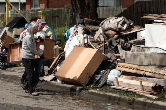 Residents near the Maribyrnong River move their flood-damaged belongings. 