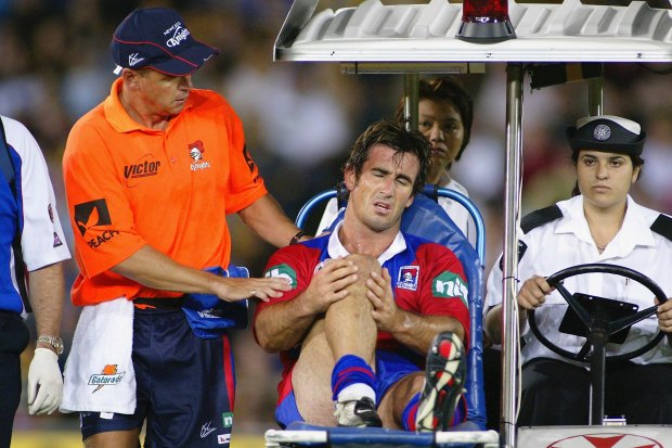 Andrew Johns is taken off the field after injuring his knee during a league match in 2004 in Sydney.