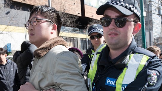 Police remove a Chinese nationalist from a Melbourne rally in support of Hong Kong democracy protesters.