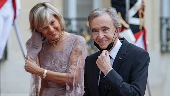 LVMH chief Bernard Arnault, with wife Helene, has been working to make sure his company will stay firmly in his family’s hands.
