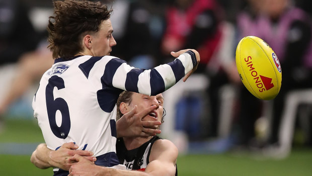 Geelong's Jordan Clark is tackled by Pie Chris Mayne. Clark dislocated his shoulder during the match.