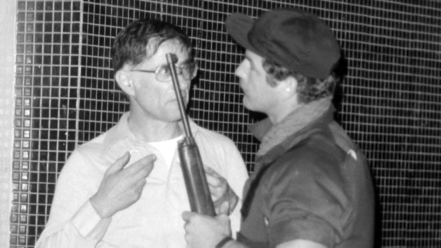 A policeman, gun in hand, talks to one of the Waiters' Club's owners during the 1978 hostage crisis.