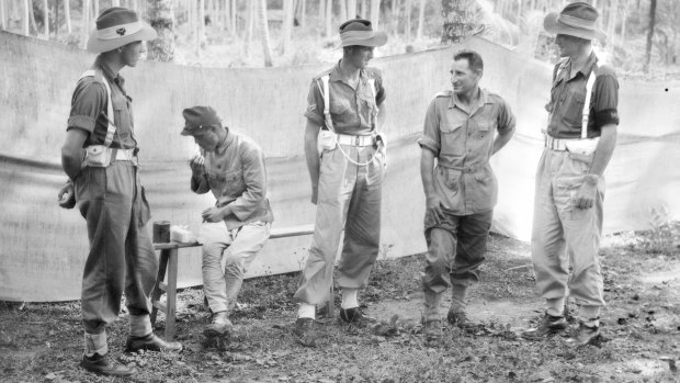 Sgt Major Tsuruo Sugino (seated) eats lunch as two provost guards talk to Warrant Officer Warrant Sticpewich, one of six survivors of Sandakan, at Labuan, Malaysian Borneo.