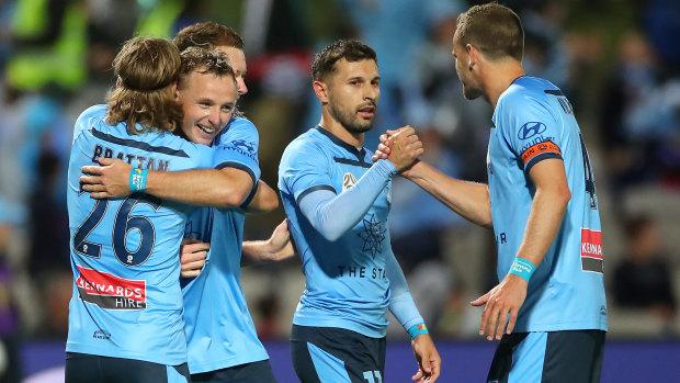Sydney FC celebrate their second and decisive goal, though Kosta Barbarouses holds back against his former club.