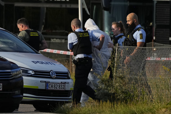 A person wearing a police-supplied white overall, is taken away by the police, near the Field’s shopping centre, after a shooting,  in Copenhagen, Denmark