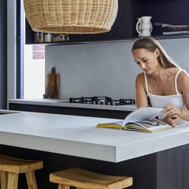 “Because of the open-plan living, and because there’s only two of us, we have all our meals at the kitchen bench,” says Kate. “It is one of my favourite spots.”  The kitchen bench is Caesarstone in “Cloudburst Concrete”, the lampshades are from Ur Place and the wooden stools are by Uniqwa Collections.  