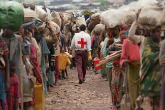 November 1996: A member of the Red Cross walks in the middle of two columns of Rwandan Hutus fleeing back to their homeland to escape war in what was then Zaire and is now the Democratic Republic of Congo.