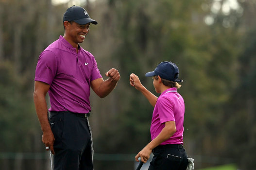 Tiger Woods and son Charlie Woods high five after a birdie on the ninth hole during the first round of the PNC Championship at the Ritz Carlton Golf Club on December 19, 2020 in Orlando, Florida.