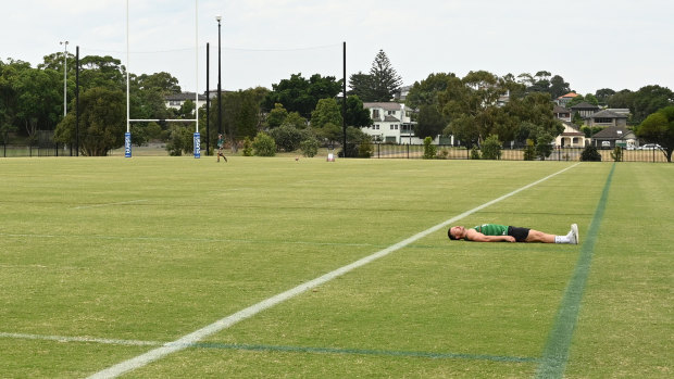 South Sydney Rabbitohs hooker Damien Cook lying down to show the width difference between a regular NRL field and the one they will use in Las Vegas.