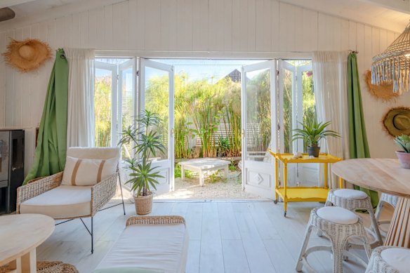 A casa de praia tem tectos altos e um jardim.