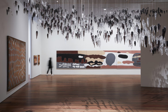 The Indigenous art gallery, Yiribana, has moved from the original building’s basement up to the entrance level of Sydney Modern. Pictured: Willy Tjungurrayi’s Tingari story 1986 (left), Yhonnie Scarce’s Death zephyr 2017 (top) and Rusty Peters’ Waterbrain 2002 (centre).