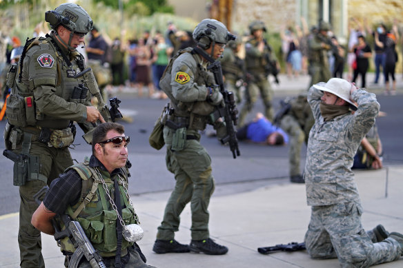 Albuquerque police detain members of the New Mexico Civil Guard, an armed civilian group, following the shooting of a man during a protest over a statue of a conquistador.