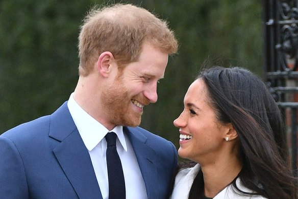 Prince Harry and Meghan Markle smile as they pose for the media in the grounds of Kensington Palace to announce their engagement.