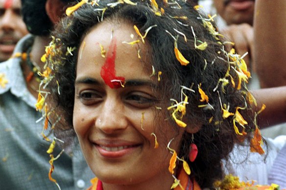 Roy being showered with flower petals at Parthrad village in central India, in 1999, where she lent her support against the Narmada Dam project.