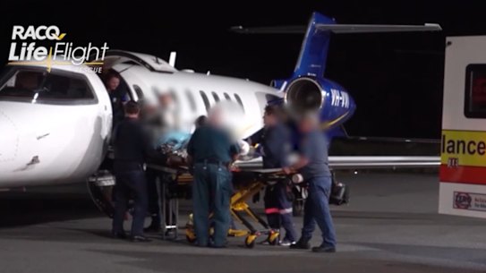 One of the injured miners lands at Brisbane Airport. All five suffered upper torso and airway burns.