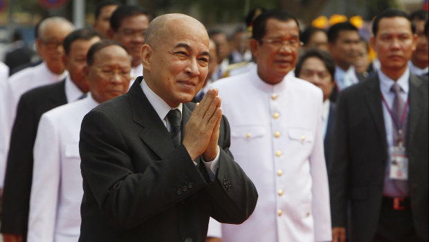 Cambodian King Norodom Sihamoni, foreground, greets his government officers in front of the National Assembly in Phnom Penh last week. Prime Minister Hun Sen is to his right inthe background.